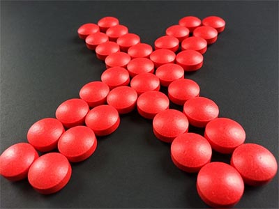 Pastillas rojas que forman una x, como indicando que fuera las pastillas